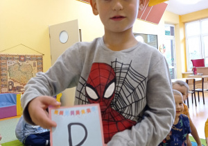 chłopiec stoi z literą P